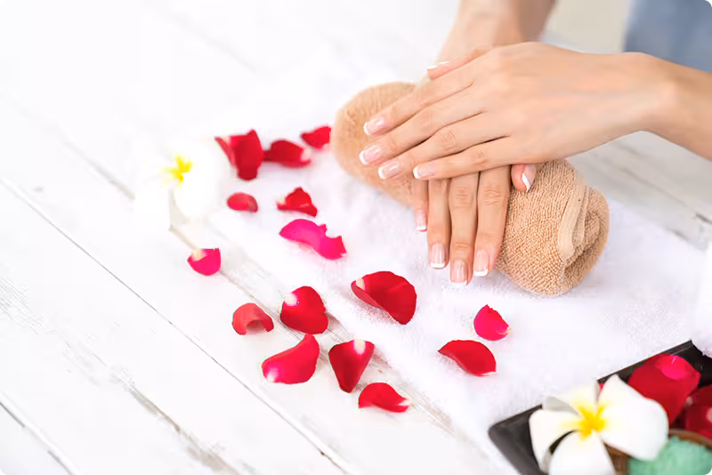 Beautiful manicure with fragrant rose petals and towel
